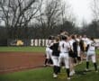 Excited softball team celebrates a victory on the field with joyful expressions and team spirit.