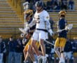 High school lacrosse players compete on a field, showcasing dynamic movement and teamwork in an exciting match.