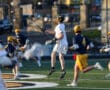 High school lacrosse players compete on the field, showcasing athletic moves and teamwork during a game.