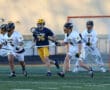 High school lacrosse players in action on the field, showcasing teamwork and competition during a game.