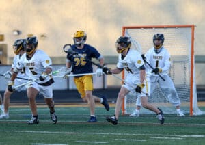 High school lacrosse players in action on the field, showcasing teamwork and competition during a game.
