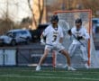 High school lacrosse players in action during a game, showcasing athleticism and teamwork on the field.