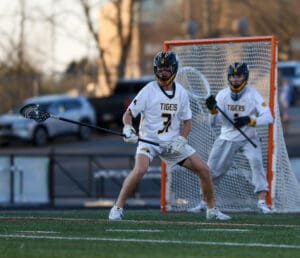 High school lacrosse players in action during a game, showcasing athleticism and teamwork on the field.