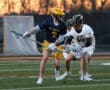 Lacrosse players from Mt. Lebanon and Tigers compete for the ball on a field during a dramatic sunset.