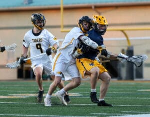 High school lacrosse players compete fiercely, showcasing athleticism on the field during an intense match.