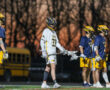 Lacrosse players in action during a sunset game, showcasing teamwork and competitive spirit on the field.