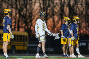 Lacrosse players in action during a sunset game, showcasing teamwork and competitive spirit on the field.