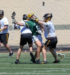 Lacrosse players in action, battling for possession on the field during a sunny day, showcasing athleticism and teamwork.