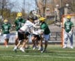 High school lacrosse players compete in an intense game, showcasing athleticism and teamwork on the field.