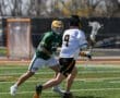 Two lacrosse players compete on a bright, sunny day, showcasing dynamic movement and athleticism on the field.