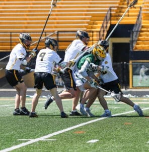 High school lacrosse players compete fiercely on the field, showcasing teamwork and athleticism during a match.