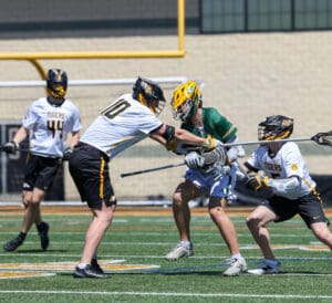 High school lacrosse players engage in a competitive game on a sunny field, showcasing athleticism and teamwork.