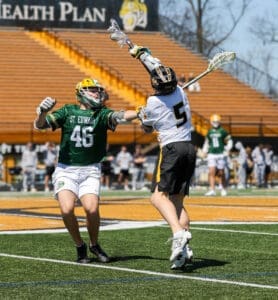 St. Edward's lacrosse player (#46) defends as opposing player (#5) attempts a shot during an intense game.