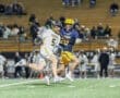 High school lacrosse players compete on the field, showcasing dynamic action and teamwork during the game.