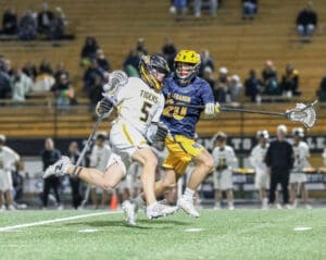 High school lacrosse players compete on the field, showcasing dynamic action and teamwork during the game.