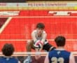 High school volleyball player sets up for a serve during a game at Peters Township, showcasing athletic focus and teamwork.