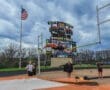 High jumper clears the bar at Wright Field, North Allegheny, with spectators and flag in the background.