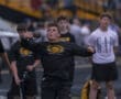 High school athlete competing in shot put during track and field event, showcasing focus and athleticism.