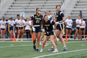 Girls' flag football team in action, showcasing teamwork and competitive spirit on the field.