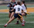 High school girls' flag football action, with player #7 evading defenders on the field. Exciting sports moment captured.