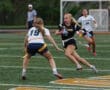 Girls' flag football game action, with one player sprinting past an opponent on the field, showcasing competitive spirit.
