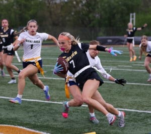 High school girls flag football players in action, showcasing competitive spirit on the field.