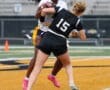 Two female athletes compete in a flag football game, showcasing dynamic action on the field.