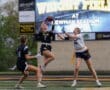 Exciting action shot of female athletes in a flag football game at Newman Stadium, capturing a key interception play.