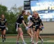 High school girls' flag football team celebrates a play at Wright Stadium, showcasing teamwork and sportsmanship.