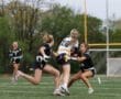 Action shot of female flag football players competing on the field, showcasing athleticism and teamwork.