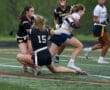 Two female athletes compete in a flag football game, demonstrating teamwork and athleticism on the field.