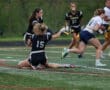 A dynamic moment in a girls' flag football game, showcasing teamwork and athleticism on an outdoor field.