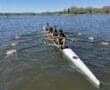 Rowing team practicing on a sunny day, showcasing teamwork and athleticism on a calm lake.