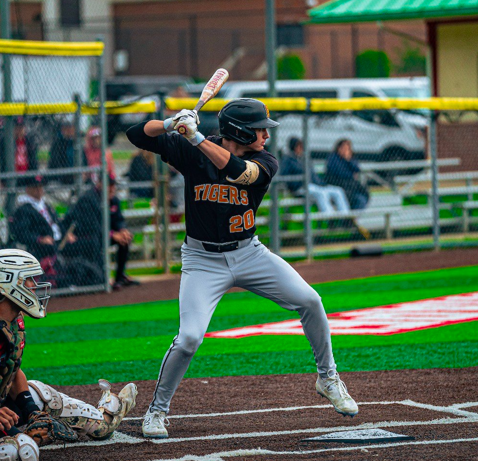 Baseball player in action, ready to bat on the field, wearing a Tigers uniform, with a catcher in position.