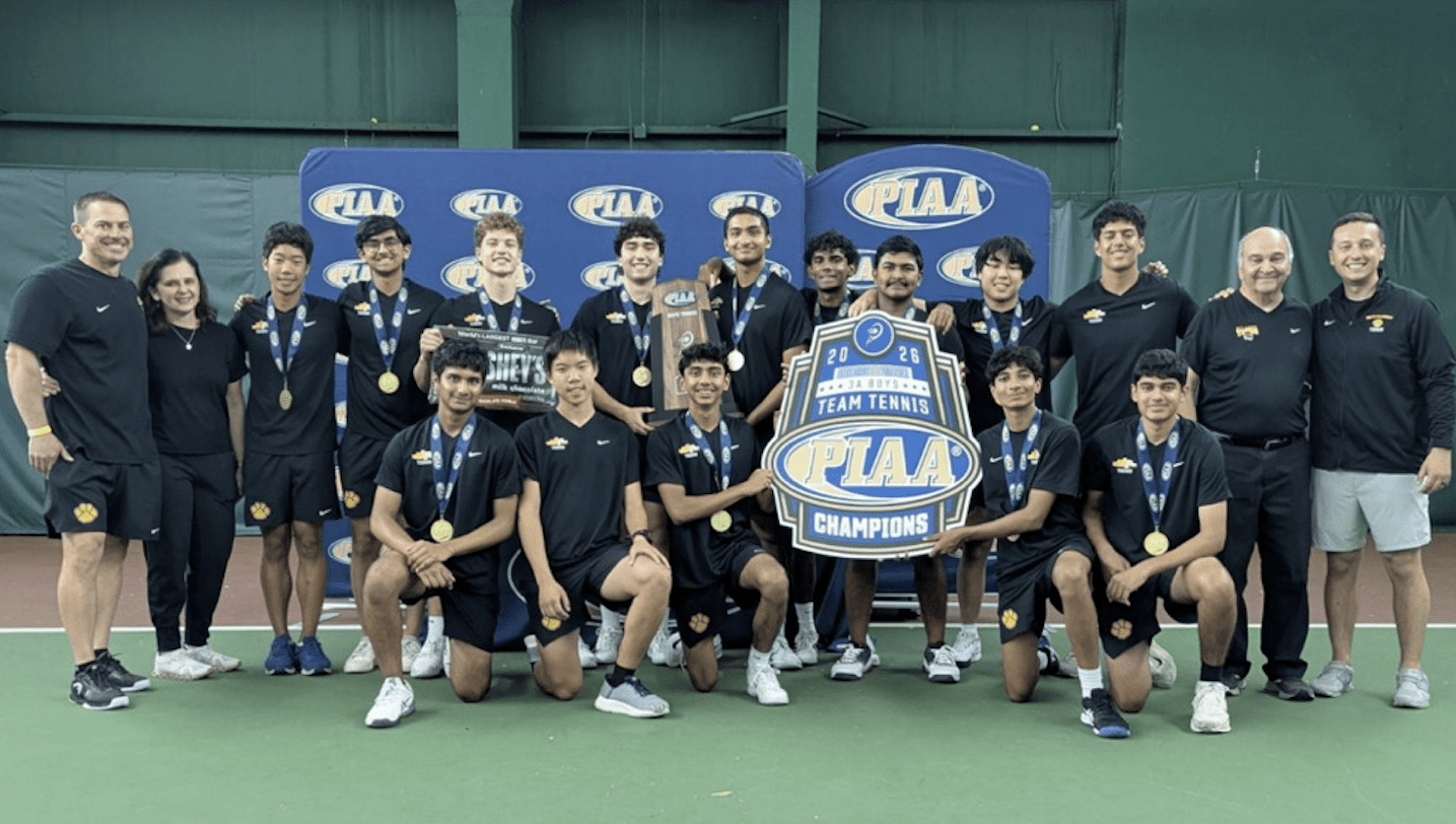 PIAA Champions boys' tennis team poses with trophy and medals, celebrating their 2026 victory indoors.