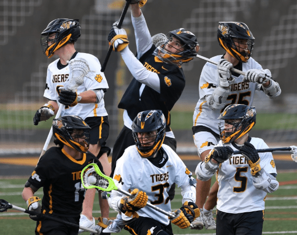 A group of lacrosse players in action, showcasing teamwork and dynamic plays on a field.