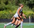 A female soccer player sprinting on the field during a match, showcasing athleticism and teamwork in action.