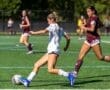 Two female soccer players competing on a field during a match, showcasing athleticism and teamwork.