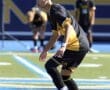 Young soccer player prepares to kick a ball during a game on a sunny field, focused and determined.