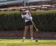 Young woman swinging a golf club on a lush green course, ready to make a perfect shot.
