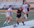 High school soccer players compete on the field, showcasing athleticism and teamwork during an intense match.