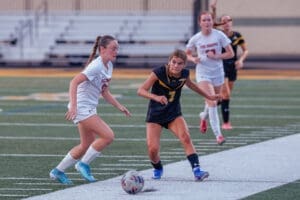High school soccer players compete on the field, showcasing athleticism and teamwork during an intense match.