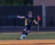 Soccer player in action kicking a ball on the field during a game, wearing a Tigers jersey.