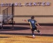 A player in a black and yellow soccer uniform prepares for a throw-in at the Baierl Center stadium.