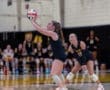 High school volleyball players set to receive a serve, showcasing teamwork and athleticism in action.