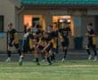 Boys soccer team celebrating a goal on the field, showcasing teamwork and excitement in a competitive match.