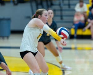 Player successfully receives a volleyball during a competitive match, showcasing athleticism and teamwork on the court.