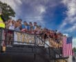 Group of excited fans cheering at a sports event, wearing team colors and U.S. flag attire, celebrating with enthusiasm.