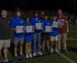 Students receive academic achievement awards during a night sports event, celebrating their success on the field.