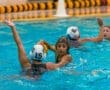 High school water polo players compete in the pool, showcasing teamwork and athleticism during a match.
